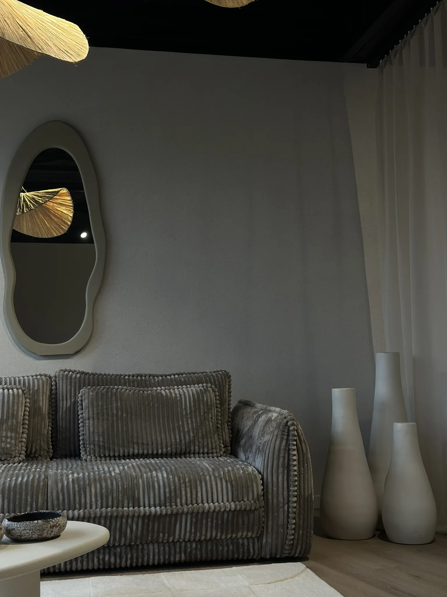 Grijze sofa in ribstof met spiegel en decoratie
